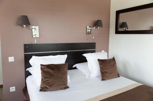 a bedroom with a bed with white sheets and pillows at Zenitude Swiss Apparthotels in Ferney-Voltaire