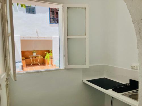 a white kitchen with a window and a table at Hostal Pons in Palma de Mallorca
