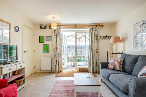 a living room with a couch and a table at Hop Cottage in East Dean