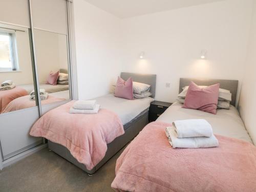 a bedroom with two beds and a mirror at Harry's Lodge in Chesterfield