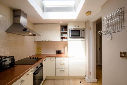 a kitchen with white cabinets and a skylight at The Stillorgan Village in Dublin