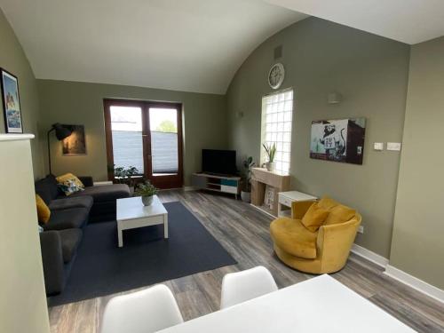 a living room with a couch and a tv at The Stillorgan Village in Dublin