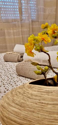 une rangée d'oreillers avec des fleurs jaunes dans un vase dans l'établissement Residence San Ferdinando, à San Ferdinando di Puglia