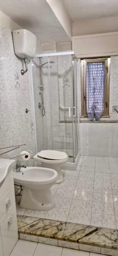 La salle de bains blanche est pourvue d'une douche et de toilettes. dans l'établissement Residence San Ferdinando, à San Ferdinando di Puglia