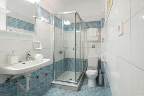 een badkamer met een douche, een wastafel en een toilet bij Tereza Apartments in Acharavi