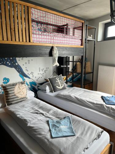 2 Betten nebeneinander in einem Zimmer in der Unterkunft Surf Rescue Club in Grömitz