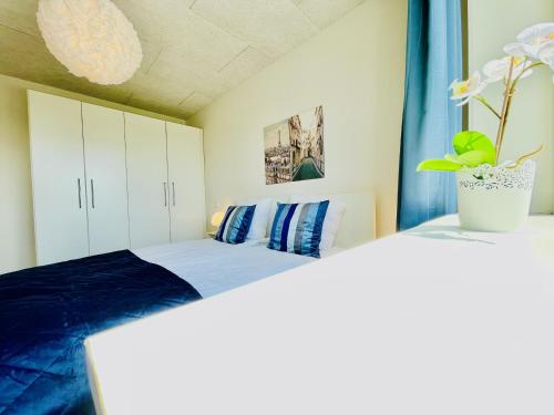 a bedroom with a bed with blue sheets at aday - Northern light apartment in Frederikshavn
