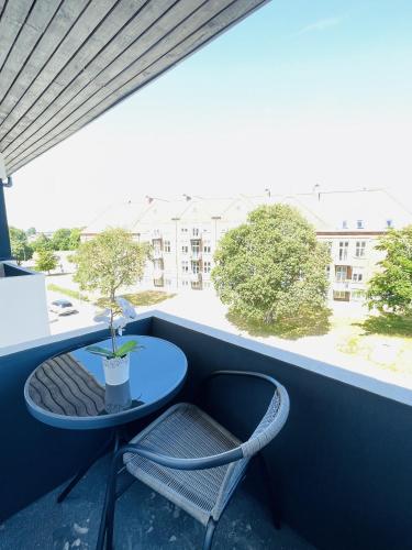 a small table and a chair on a balcony at aday - Northern light apartment in Frederikshavn