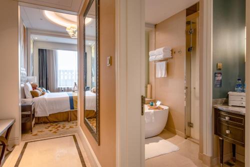 a bathroom with a large mirror and a bedroom at Sofitel Shanghai Hongqiao in Shanghai