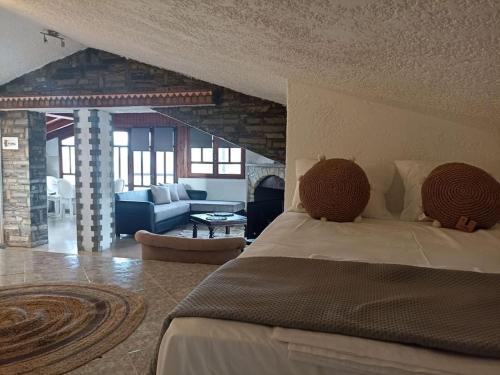 Cozy house في Tagarades: غرفة نوم مع سرير وغرفة معيشة