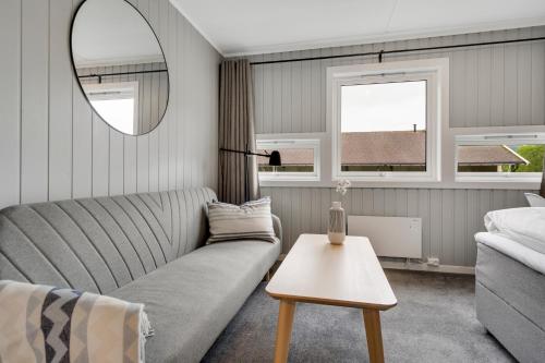 a living room with a couch and a mirror at Mosjøen Apartmens in Mosjøen