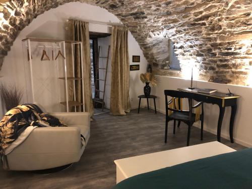 un salon avec un canapé, une table et un bureau dans l'établissement Les rives du Dourdou, à Bozouls