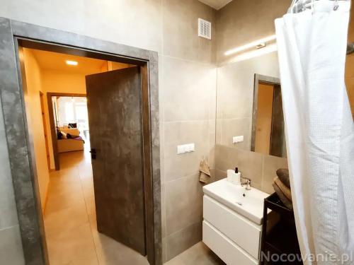 een badkamer met een wastafel en een spiegel bij Apartament in Oboźna Droga Masłów
