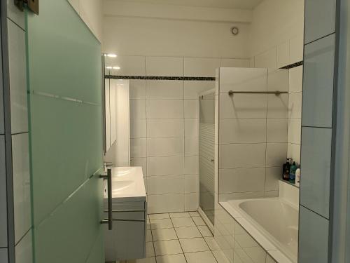 een badkamer met een douche, een wastafel en een bad bij The Brussels-Laken Appartement in Brussel