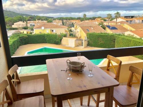 - une table avec des verres à vin et une vue sur la piscine dans l'établissement Studio 322, Port Vénus au village naturiste, au Cap d'Agde