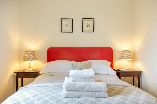 um quarto com uma cama com toalhas em Little Scarlet em East Dean