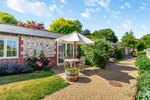 a patio with an umbrella and a table at Little Scarlet in East Dean