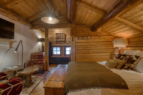 1 dormitorio en una cabaña de madera con 1 cama y 1 mesa en Le Vieux Chalet, en La Clusaz