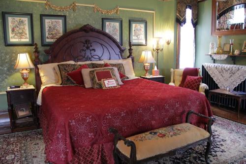 a bedroom with a large bed with a red blanket at Schuster Mansion Bed & Breakfast in Milwaukee