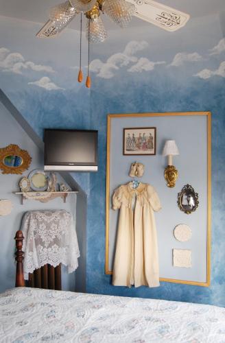 a bedroom with blue ceilings and a bed with a dress on the wall at Schuster Mansion Bed & Breakfast in Milwaukee