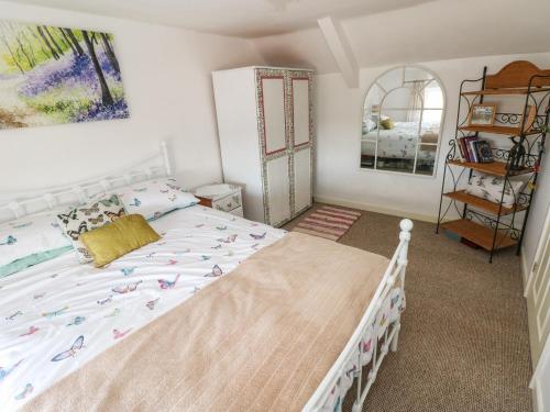 Un dormitorio con una cama blanca con pájaros. en Daisys Cottage, en Burry Port