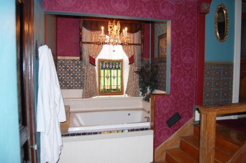 a bathroom with a bath tub and a window at Schuster Mansion Bed & Breakfast in Milwaukee