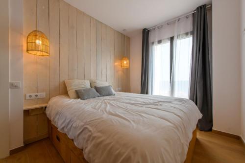 een slaapkamer met een groot wit bed en een raam bij Can Bailet in Cadaqués