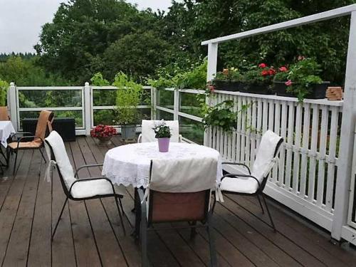 una mesa y sillas en una terraza con una valla blanca en Rosenhof Ferienwohnungen, en Mölln-Medow
