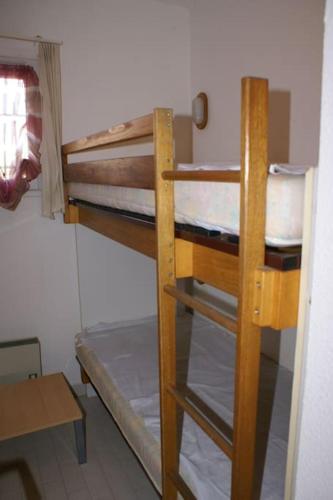 une chambre avec deux lits superposés et une table dans l'établissement Appartement cabine 908 Tennis Village 6 personnes, au Cap d'Agde
