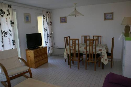 un salon avec une table, des chaises et une télévision dans l'établissement Appartement cabine 908 Tennis Village 6 personnes, au Cap d'Agde