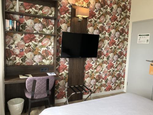 a bedroom with a flower wall with a flat screen tv at Fährhaus Hotel am Rhein by Mayburgh in Düsseldorf