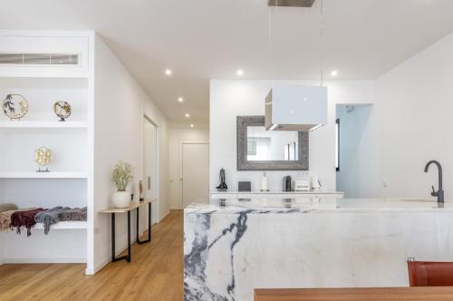 una cucina con pareti bianche e un grande bancone in marmo di Villa Mármore a Funchal