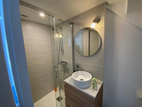 een badkamer met een wastafel en een douche met een spiegel bij Maison proximité centre-ville in Arcachon