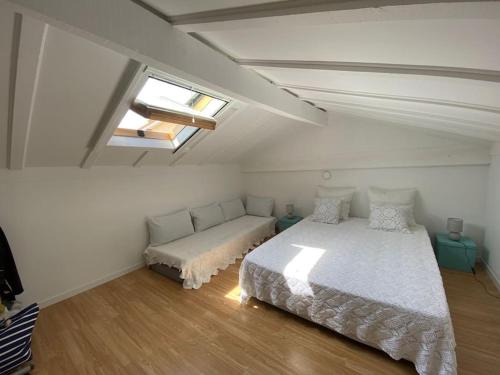een slaapkamer met een bed en een bank erin bij Maison proximité centre-ville in Arcachon