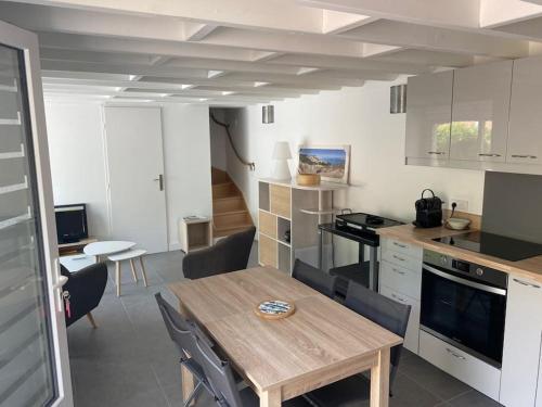 une cuisine avec une table en bois et une salle à manger dans l'établissement Maison proximité centre-ville, à Arcachon