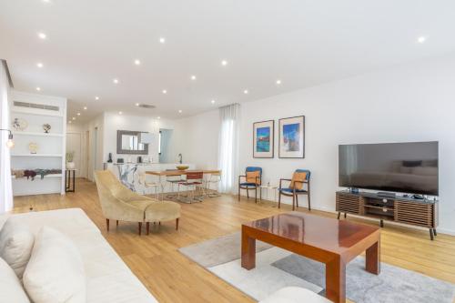 a living room with a couch and a table at Entire Villa, Bay Views, Private Rooftop & BBQ in Funchal