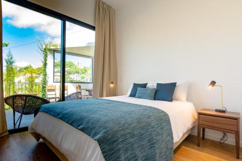 una camera con un grande letto e una grande finestra di Villa Mármore a Funchal