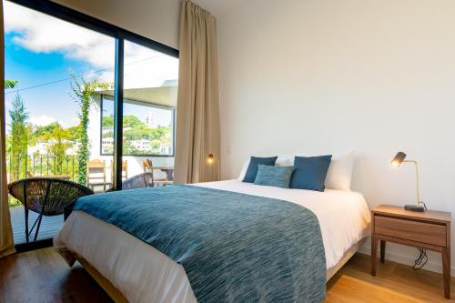 una camera da letto con un letto grande e una grande finestra di Villa Mármore a Funchal