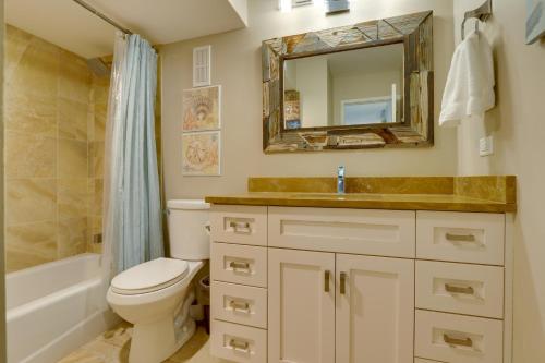 a bathroom with a toilet and a sink and a mirror at Serene Hilton Head Island Condo with Community Pool! in Hilton Head Island