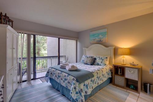 ein Schlafzimmer mit einem Bett und einem großen Fenster in der Unterkunft Serene Hilton Head Island Condo with Community Pool! in Hilton Head Island