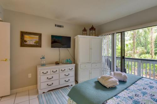 a bedroom with a bed and a dresser and a window at Serene Hilton Head Island Condo with Community Pool! in Hilton Head Island