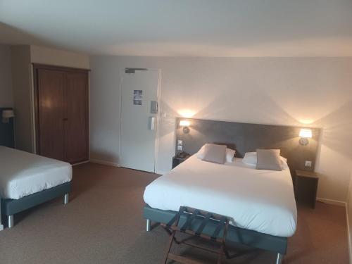 una habitación de hotel con 2 camas y una silla en Hôtel La Parenthèse en Attignat