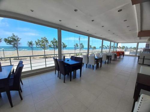 a dining room with tables and chairs and the beach at Kocaali Sun Otel in Sakarya