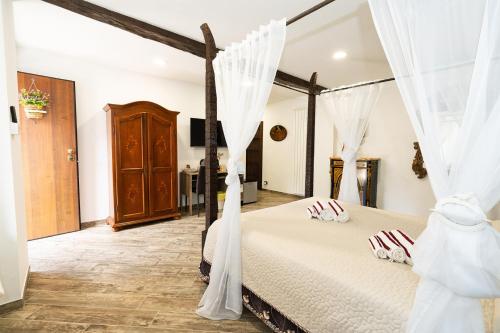 ein Schlafzimmer mit einem Himmelbett mit weißen Vorhängen in der Unterkunft Margot Family in Venaria Reale