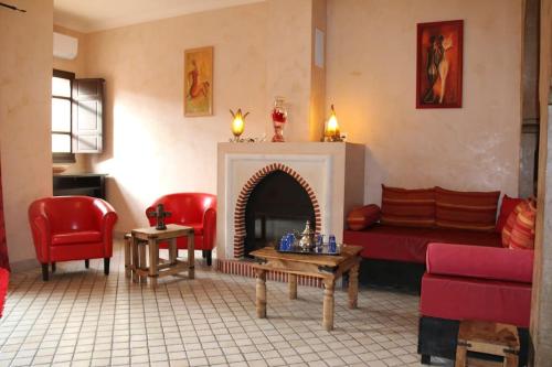ein Wohnzimmer mit einem Sofa und einem Kamin in der Unterkunft Chambre Merzouga, Riad 8 au village naturiste Couple only in Cap d'Agde