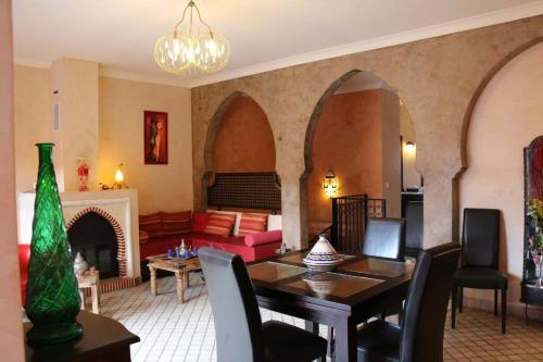 ein Wohnzimmer mit einem Tisch und einem Sofa in der Unterkunft Chambre Merzouga, Riad 8 au village naturiste Couple only in Cap d'Agde