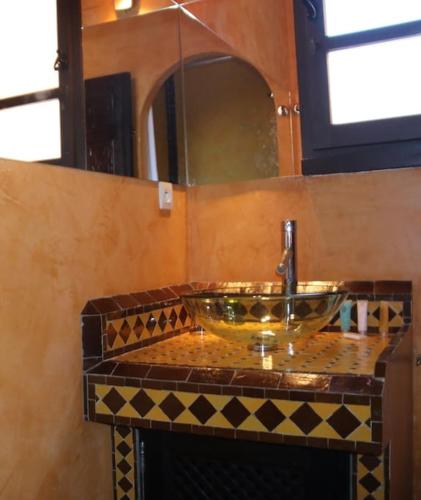 eine Badezimmertheke mit einem Waschbecken und einem Spiegel in der Unterkunft Chambre Merzouga, Riad 8 au village naturiste Couple only in Cap d'Agde