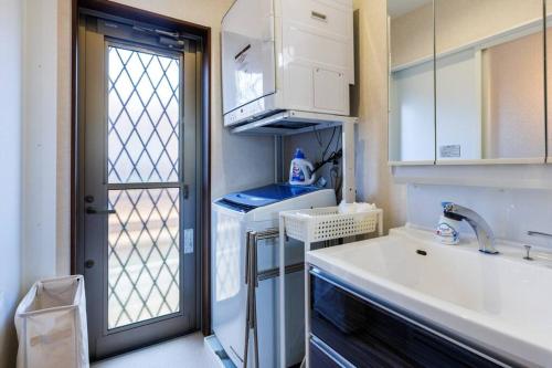 a small kitchen with a sink and a refrigerator at BBQ可/庭付き一棟貸/ビーチまで3分/古宇利島車で7分/最大8人 Luana house in Nago