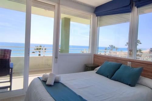 een slaapkamer met een bed en uitzicht op de oceaan bij Baix Maestrat Apartamento en 1ª línea de playa in Peñíscola