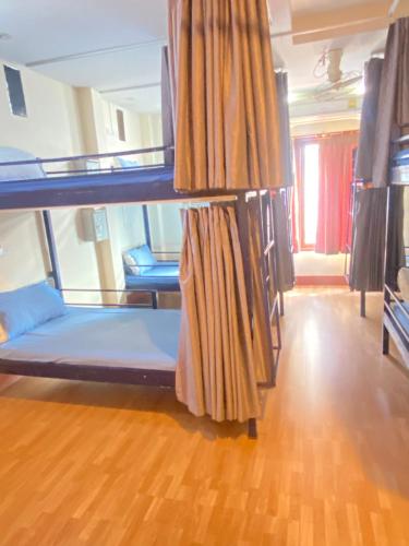 a room with two bunk beds and a wooden floor at Bluegelatohousekohtao in Ko Tao